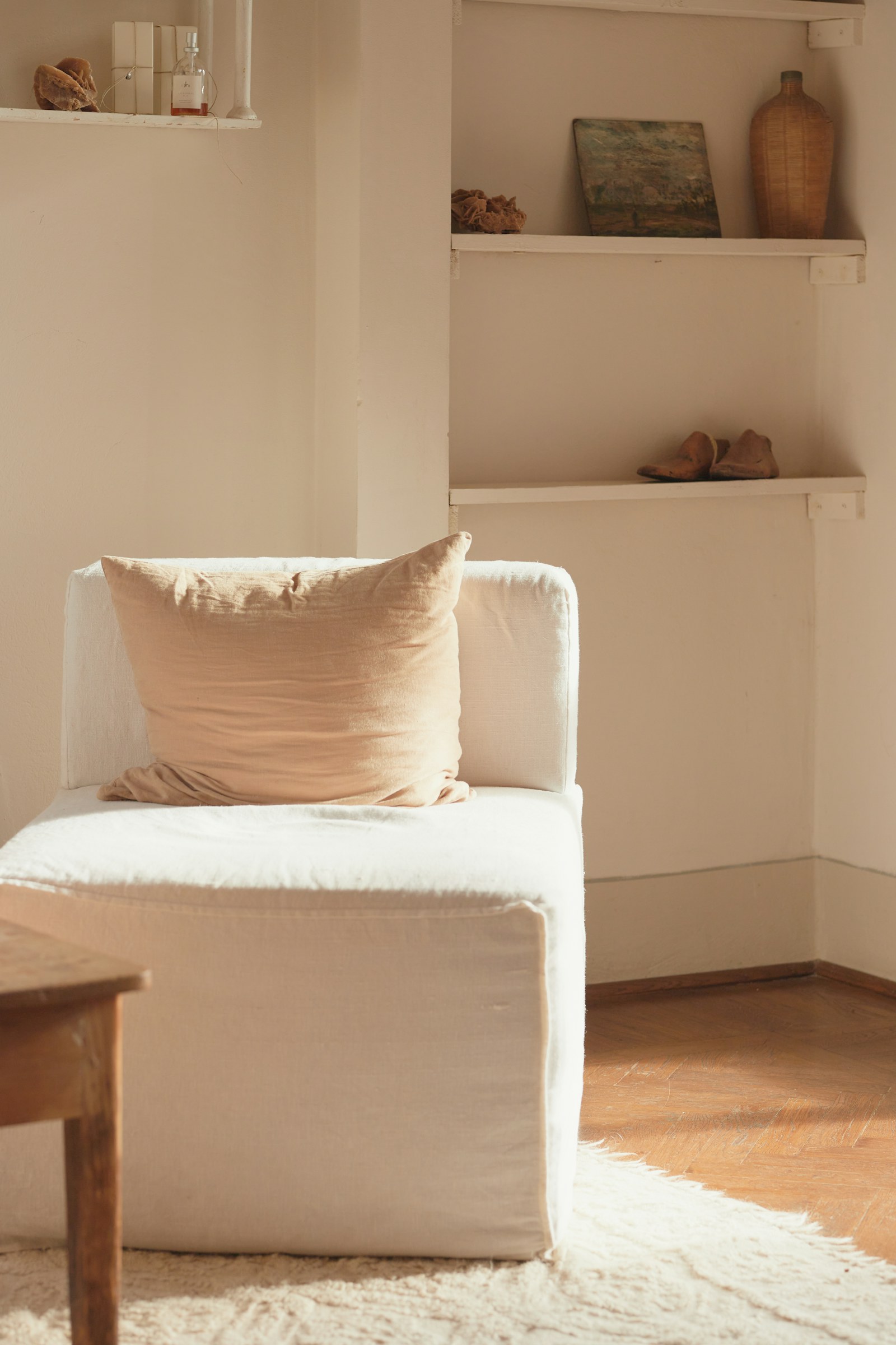Fauteuil crème et parquet éclairés par le soleil dans une maison, photo d’illustration